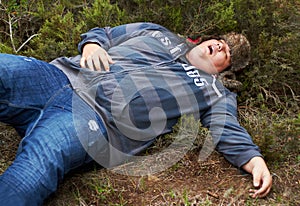 Suffering the consequences of a wild night.... An obese young man lying passed-out outside in the bushes.