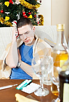 Suffering man with hangover with towel in hand