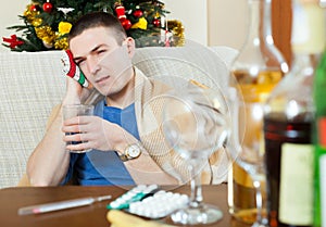 Suffering man stuping towel to head after party