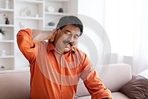 Suffering middle aged indian man feeling neck pain