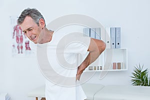 Suffering patient touching his back
