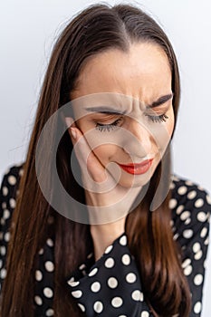 Suffering from toothache. Beautiful young woman suffering from toothache, standing against white background