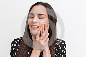 Suffering from toothache. Beautiful young woman suffering from toothache, standing against white background