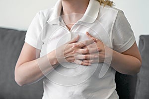 Suffering young woman having pain in chest