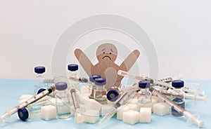 Sugar addiction, insulin resistance, unhealthy diet, figure of a cardboard man surrounded by refined sugar cubes, syringe for
