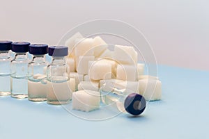 Sugar addiction, insulin resistance, unhealthy diet, sugar cubes and bottles of insulin on blue background, diabetes protection