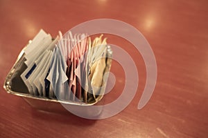 Sugar and Artificial Sweetener Packets on a wooden table