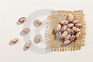 Sugar Bean legume. Close up of grains spread over white table. photo