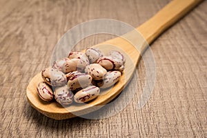 Sugar Bean legume. Spoon and grains over wooden table. photo