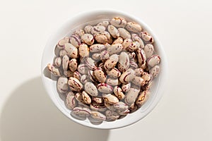 Sugar Bean legume. Top view of grains in a bowl. White background photo
