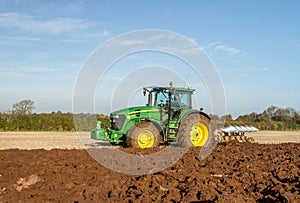 Modern John Deere tractor pulling a plough