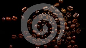 Sugar being pored onto a pile of coffee. Against black background