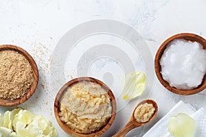 Sugar body scrub with ingredients on white stone table. Homemade cosmetic for spa