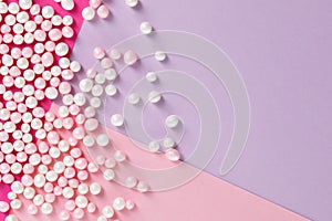 Sugar candy scattered on pastel colored background