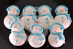 Sugar Christmas snowmen figurines on glazed muffins