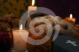 Sugary bread of the dead celebrating dia de muertos and using cempasuchienlt flowers on an altar photo