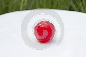 Sugar coated red cherries are used to decorate desserts in white plate.