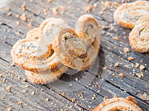 Sugar cookie curls with poppy seed puff pastry on wooden background. Confectionery for the recipe. Pastries, dessert