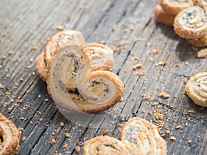Sugar cookie curls with poppy seed puff pastry on wooden background. Confectionery for the recipe. Pastries, dessert