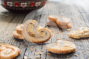 Sugar cookie curls with poppy seed puff pastry on wooden background. Confectionery for the recipe. Pastries, dessert