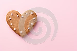 Sugar cookie in heart shape, on pink background. Valentine, love, romance concept.