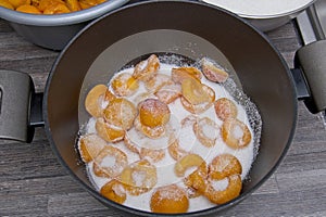 Sugar covering the apricot halves in a saucepan