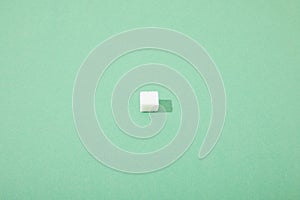 Sugar cube on green background with copy space