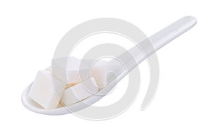 Sugar cube in spoon on white background