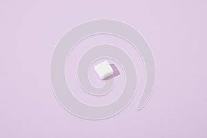 Sugar cube on violet background with copy space
