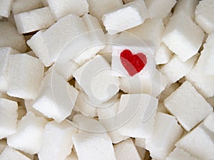 Sugar cubes with a red heart on one of them. Top view. Diet unhealty sweet addiction concept photo