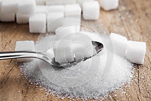 sugar cubes in spoon on table wood