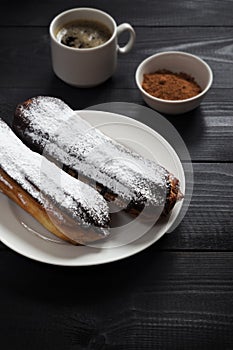 Sugar eclairs and a cup of coffee