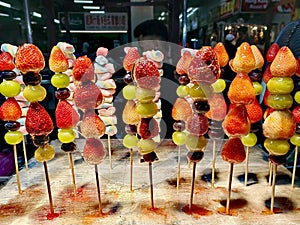 Sugar glazed fruits skewer on sale in Jalan Petaling Chinatown kuala Lumpur.