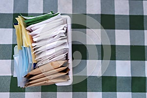 Sugar packets on a Checkered white and green table cloth