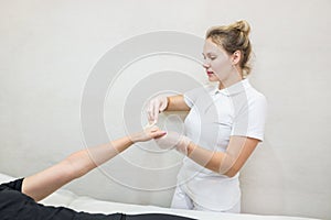 Sugar paste hair removal procedure - shugaring. Cosmetologist applies sugar paste to the hand of a young woman