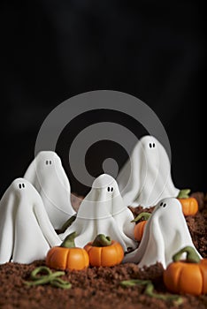 Sugar paste scene of halloween, group of ghosts in a pumpkin patch