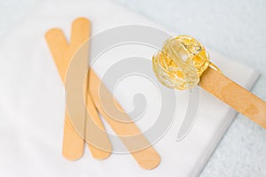 sugar paste or wax honey for hair removing with wooden waxing spatula sticks. - depilation and beauty concept