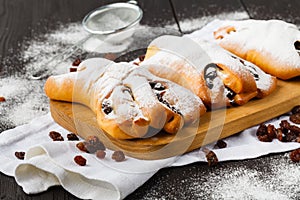 Sugar powder is poured onto a freshly baked croissan