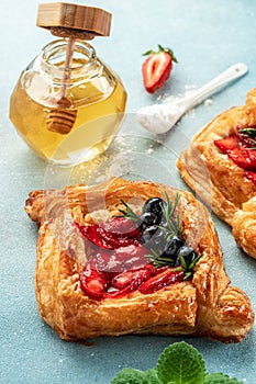 sugar powdered puff pastry, strawberry and honey. vertical image. top view. place for text