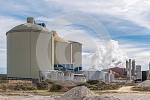 Sugar production factory with chimneys expelling smoke outside