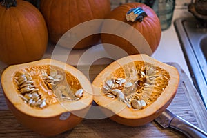 Sugar pumpkin cut in half exposing the pulp and seeds