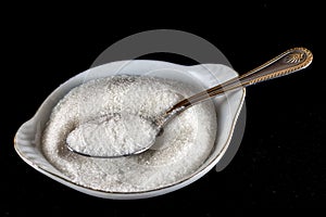 Sugar in a saucer with a spoon