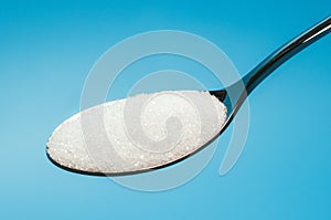 Sugar spoon blue background.
