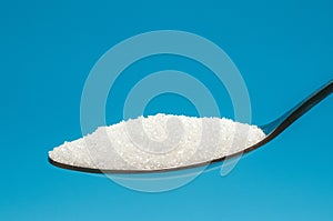 Sugar spoon blue background.