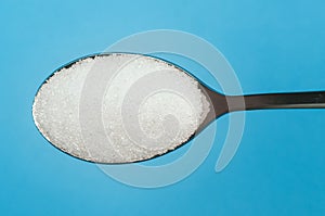 Sugar spoon blue background.