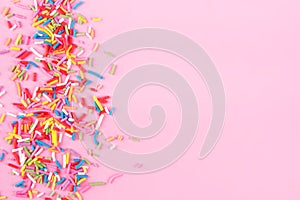 Sugar sprinkle dots hearts, decoration for cake and bakery, as a background. Isolated on pink. photo
