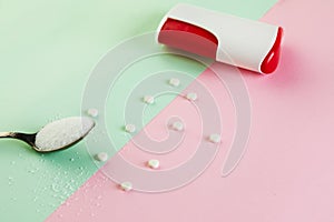 Sugar substitute tablets and natural sweetener powder on a green-pink background