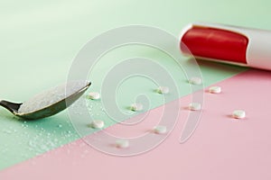 Sugar substitute tablets and natural sweetener powder on a green-pink background