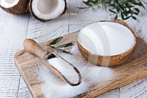 Sugar substitute in a wooden bowl on a background of coconut. Natural sweetener. Stevia, erythritol. photo