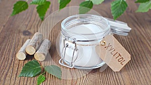 Sugar substitute xylitol, a glass jar with birch sugar on wooden background